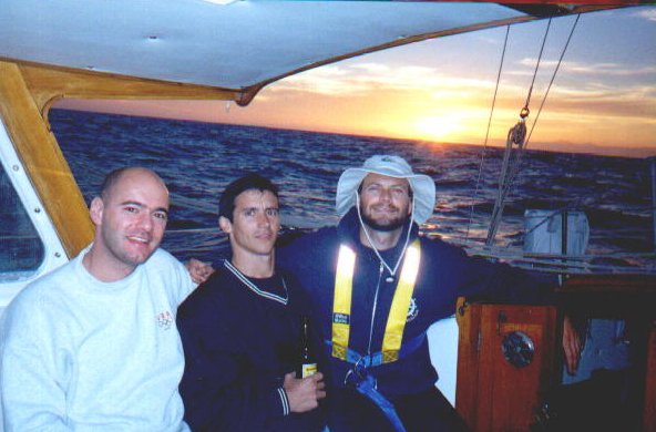 Three sailors in Condesa's cockpit at sunset